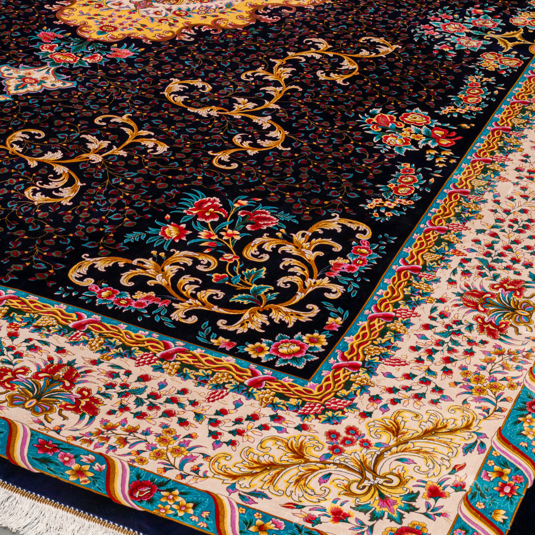Elegant navy silk rug with detailed floral medallion, ornate cream border, and rich design in gold, coral, and turquoise tones.
