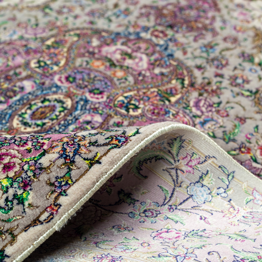 The Kale silk rug features a pink and beige floral medallion design, handwoven in fine silk with intricate detailing.