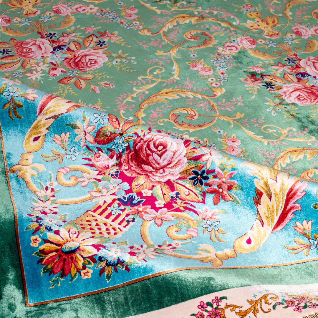 Green silk rug with detailed rose motifs and a turquoise border, featuring Persian-inspired floral designs and ornamental flourishes.