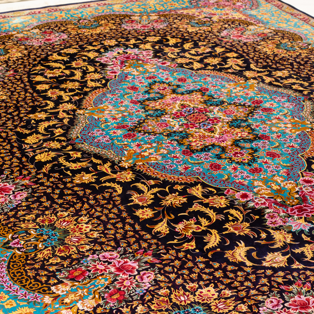 The Amore silk rug features an ornate floral medallion over a navy base, with vivid accents of turquoise, gold, and crimson in 350x250 cm.