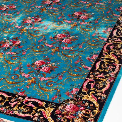 The Archie silk rug in turquoise with red floral motifs and golden scrolls, featuring a black ornamental border and exquisite handwoven detailing.