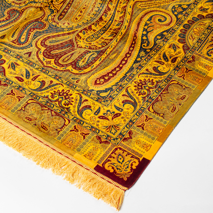 Golden silk rug with navy and red paisley floral detailing, handcrafted in a luxurious sheen finish with traditional Persian design elements.

