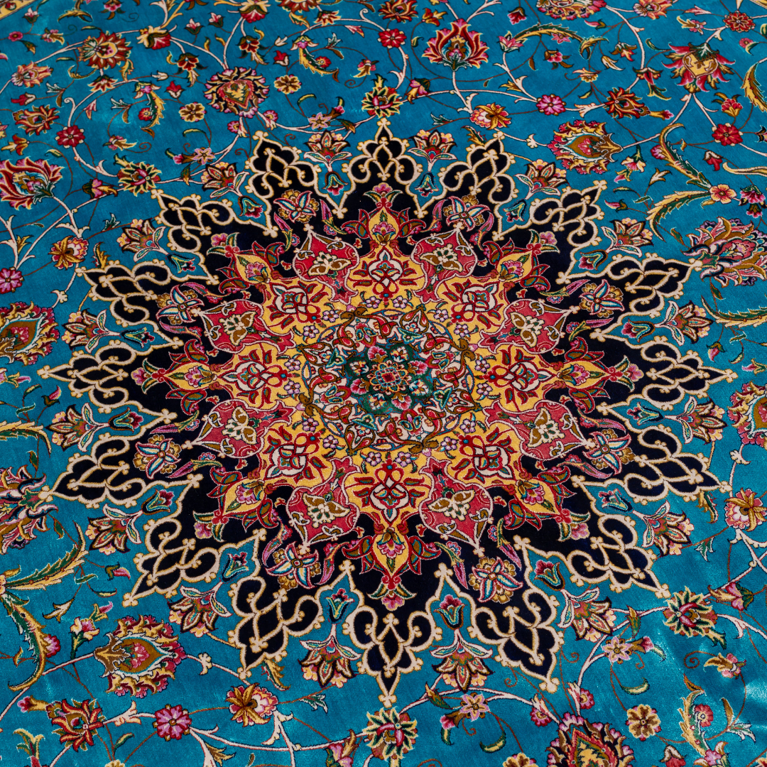 Cello Silk Rug with a turquoise base, intricate central floral medallion, and ornate navy border with Persian floral motifs and fine silk texture.