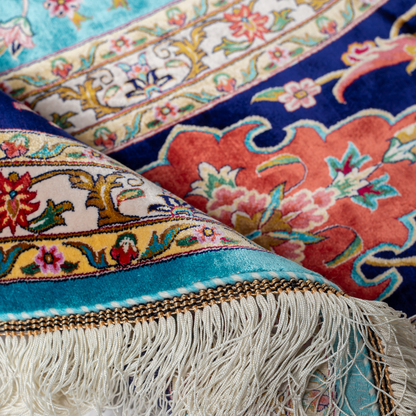 Cello Silk Rug with a turquoise base, intricate central floral medallion, and ornate navy border with Persian floral motifs and fine silk texture.