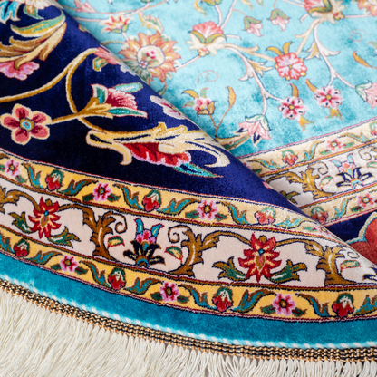Cello Silk Rug with a turquoise base, intricate central floral medallion, and ornate navy border with Persian floral motifs and fine silk texture.