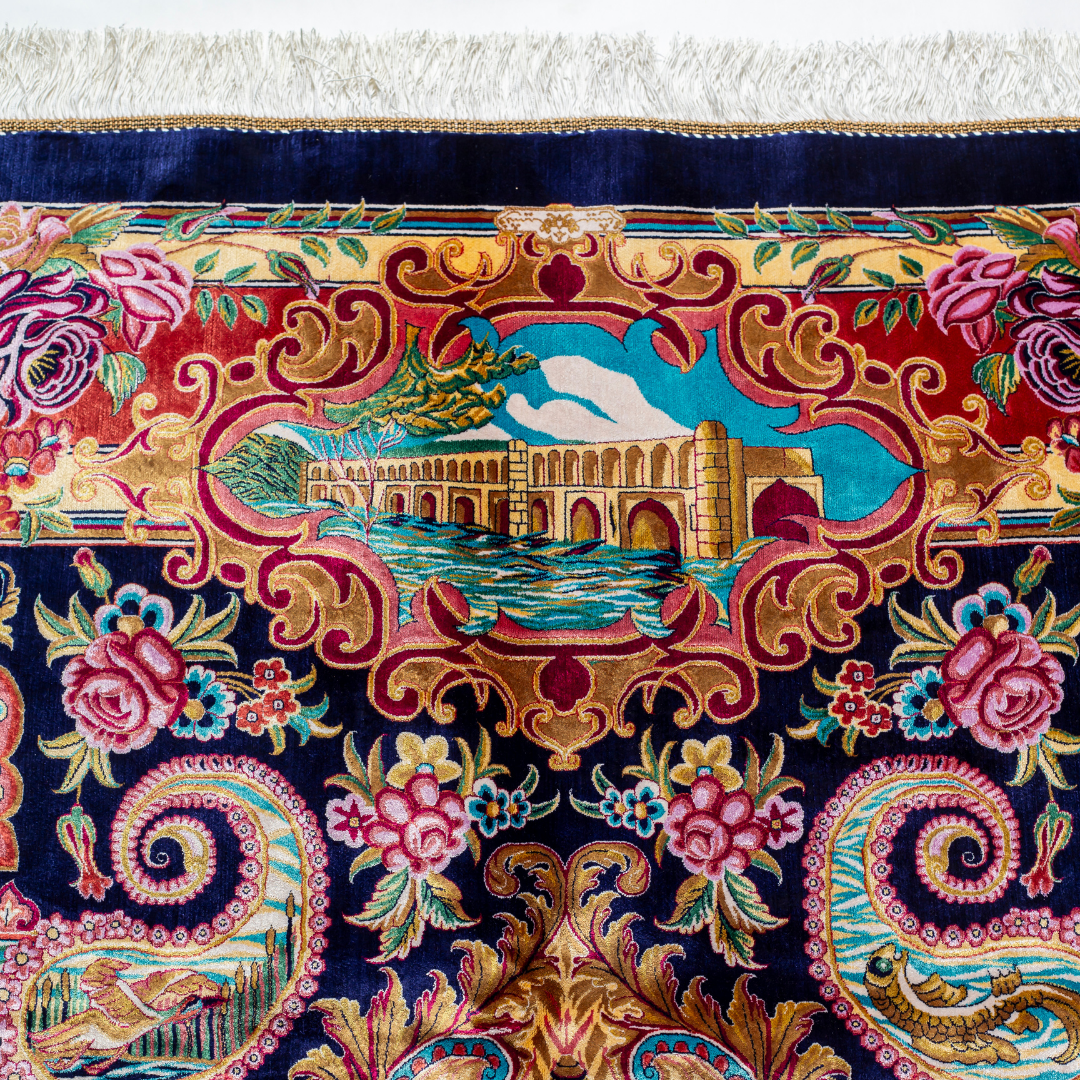 Silk rug with tree of life and bird motif, burgundy floral base, and ornate navy-gold borders. Handwoven with artistic precision.

