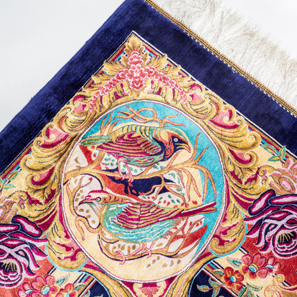 Silk rug with tree of life and bird motif, burgundy floral base, and ornate navy-gold borders. Handwoven with artistic precision.

