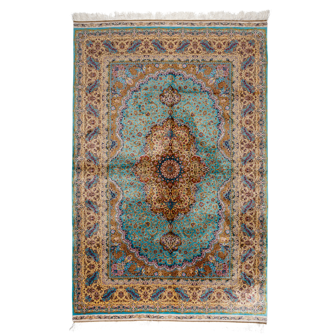 Intricately handwoven silk rug with medallion design, turquoise base, and ornate gold-maroon border for elegant interior styling.

