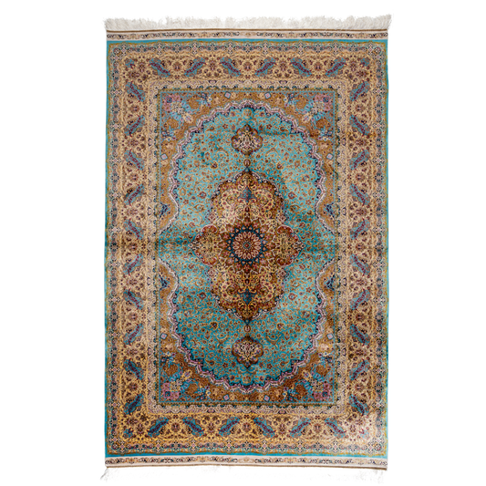 Intricately handwoven silk rug with medallion design, turquoise base, and ornate gold-maroon border for elegant interior styling.


