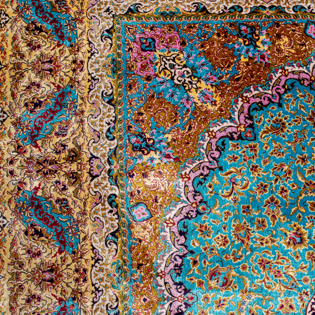 Intricately handwoven silk rug with medallion design, turquoise base, and ornate gold-maroon border for elegant interior styling.

