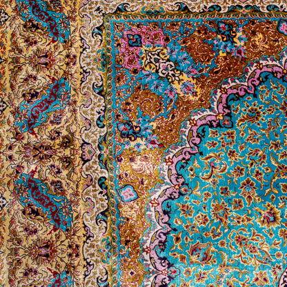 Intricately handwoven silk rug with medallion design, turquoise base, and ornate gold-maroon border for elegant interior styling.

