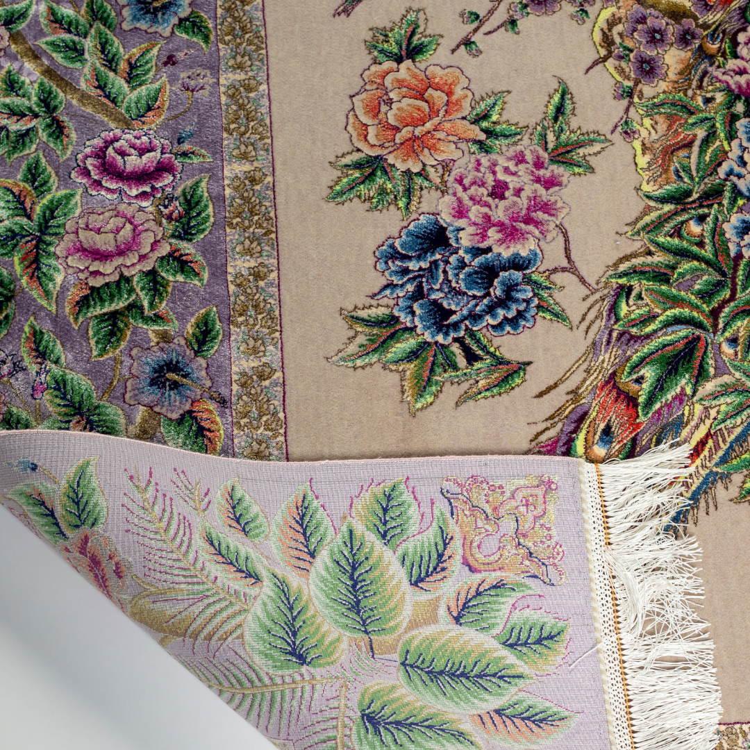 Elegant silk rug with peacock and floral design in soft pastels. Framed by intricate vine borders. A handwoven masterpiece of grace.

