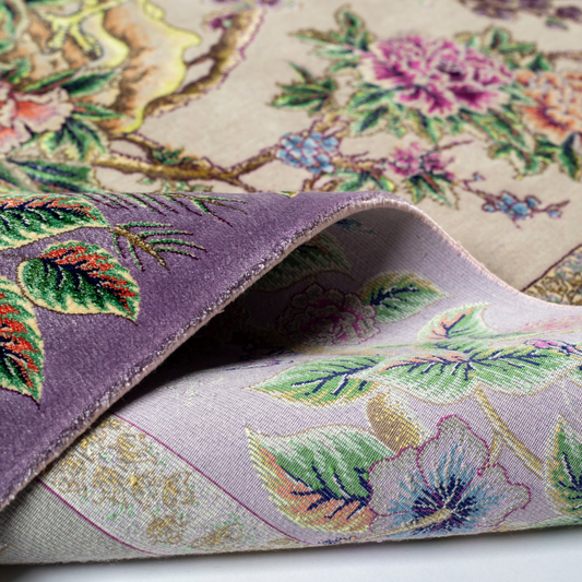 Elegant silk rug with peacock and floral design in soft pastels. Framed by intricate vine borders. A handwoven masterpiece of grace.

