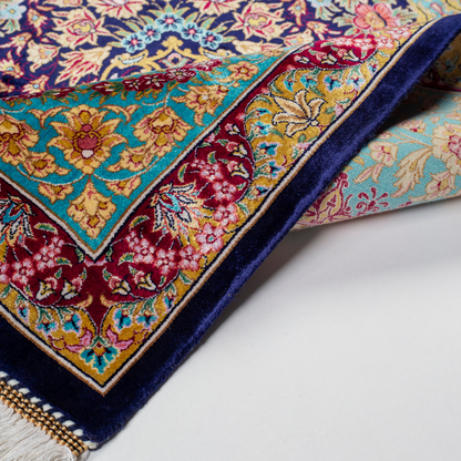 Luxurious silk rug with intricate medallion and floral design in jewel tones. Elegant handwoven detailing for sophisticated interiors.

