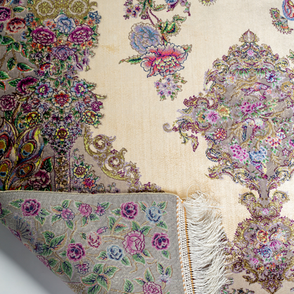 Luxurious ivory silk rug featuring peacocks, floral motifs, and intricate detailing, handcrafted with multicolored threads.