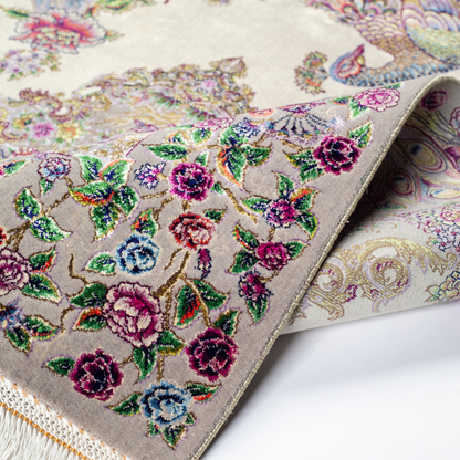 Luxurious ivory silk rug featuring peacocks, floral motifs, and intricate detailing, handcrafted with multicolored threads.
