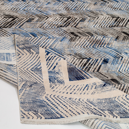 Eclipse cotton rug featuring a bold chevron pattern in grey, blue, and ivory with a distressed texture, perfect for contemporary interiors.