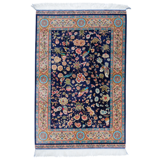 Eden silk rug featuring navy base with multi-colour florals and birds, hand-finished with detailed borders.

