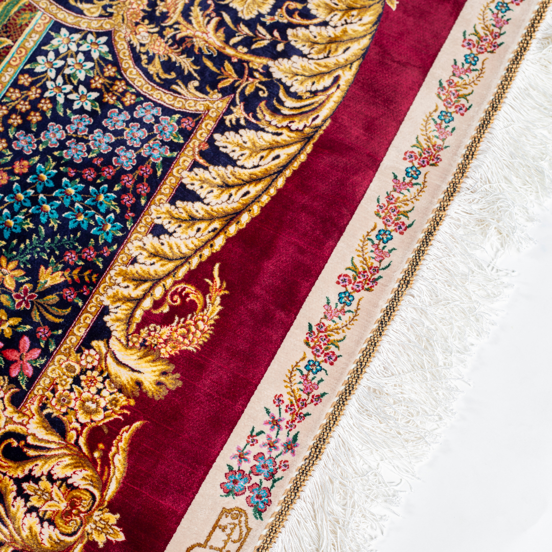 Silk rug with tree of life and bird motif, burgundy floral base, and ornate navy-gold borders. Handwoven with artistic precision.


