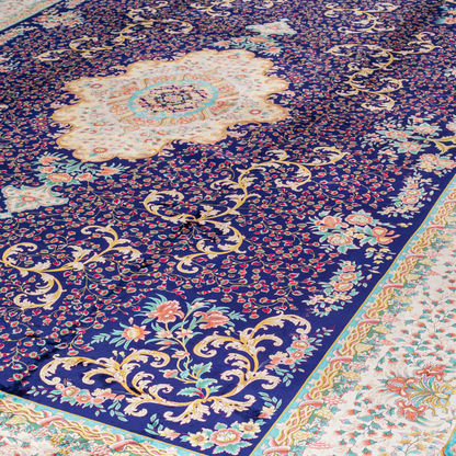 Elegant navy silk rug with detailed floral medallion, ornate cream border, and rich design in gold, coral, and turquoise tones.