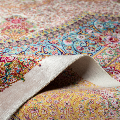 Silk Flow rug with a floral rosette medallion, ivory base, and ornate border in saffron, turquoise, plum, and blush tones.