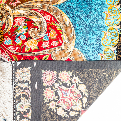 Luxury blue silk rug featuring a detailed central medallion, floral motifs, and ornate bird patterns in gold, coral, and black accents.