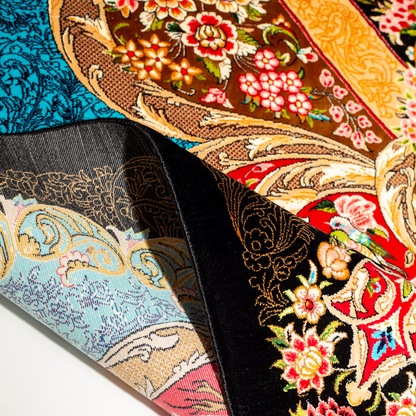 Luxury blue silk rug featuring a detailed central medallion, floral motifs, and ornate bird patterns in gold, coral, and black accents.