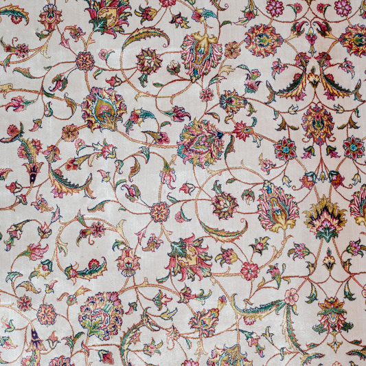 Ivory silk rug with intricate floral patterns in navy, rose, gold, and turquoise, framed with an ornate navy border.


