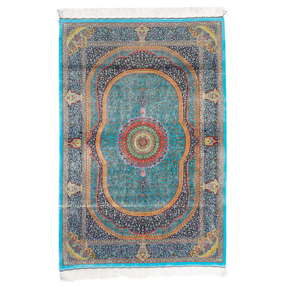Jaze Silk Rug featuring a central floral medallion on a turquoise base with red, green, and black detailing, size 150x100 cm.