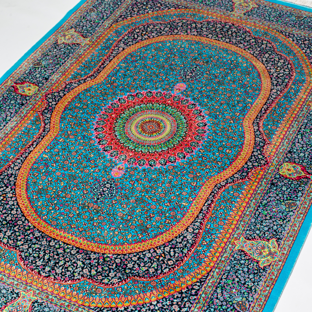 Jaze Silk Rug featuring a central floral medallion on a turquoise base with red, green, and black detailing, size 150x100 cm.