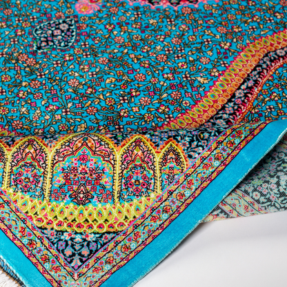 Jaze Silk Rug featuring a central floral medallion on a turquoise base with red, green, and black detailing, size 150x100 cm.