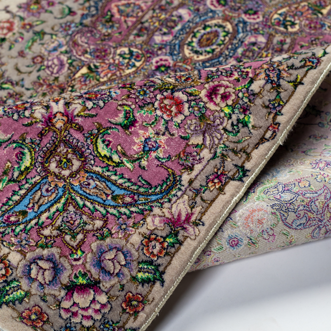 The Kale silk rug features a pink and beige floral medallion design, handwoven in fine silk with intricate detailing.