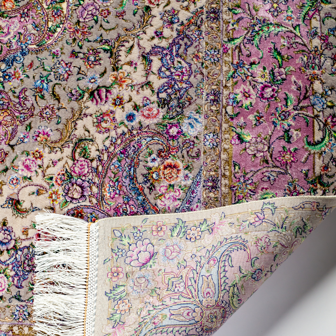 The Kale silk rug features a pink and beige floral medallion design, handwoven in fine silk with intricate detailing.