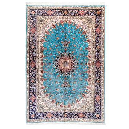 Intricately designed silk rug with turquoise base, floral patterns, and central medallion in red and gold – hand-finished and richly detailed.