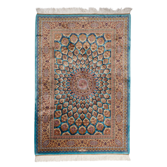 Maki silk rug featuring a turquoise blue base with intricate gold, ruby red, ivory, and fuchsia floral medallion design in a symmetrical pattern.

