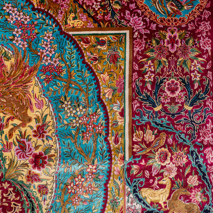 Opulent silk rug with ruby base and turquoise floral accents. Detailed handwoven artistry ideal for luxury, dramatic interior settings.

