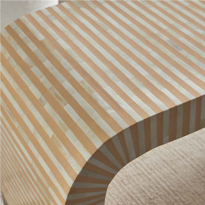 Modern beige bone inlay coffee table with curved edges and gold base. Features a striped inlay design for an elegant aesthetic.