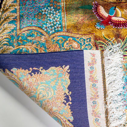 Elegant silk rug with flying birds and floral tree scene, bordered in ornate gold and blue. Handwoven with incredible detail and texture.

