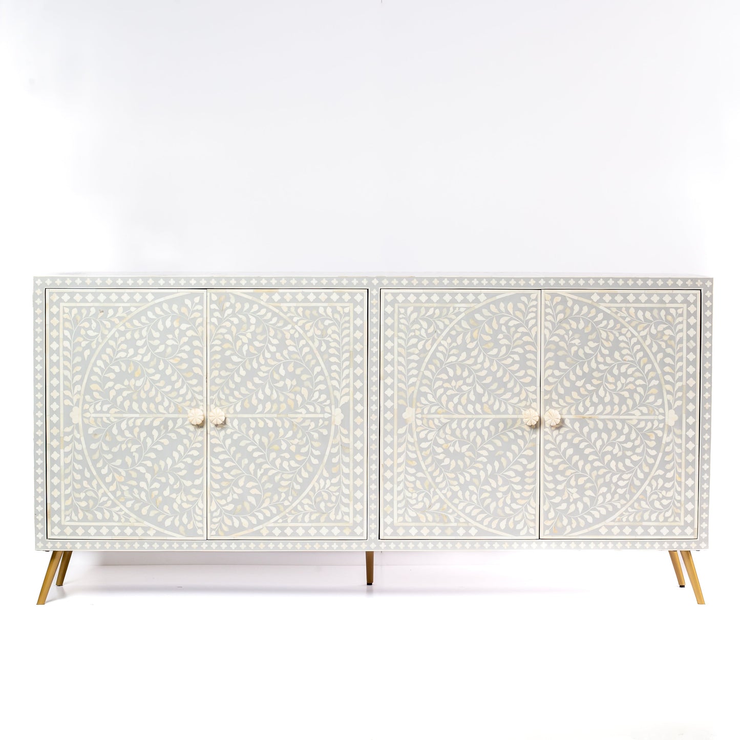 Grey bone inlay cabinet with floral vine pattern, brass legs, and carved bone knobs, handcrafted with spacious storage and artisanal charm.