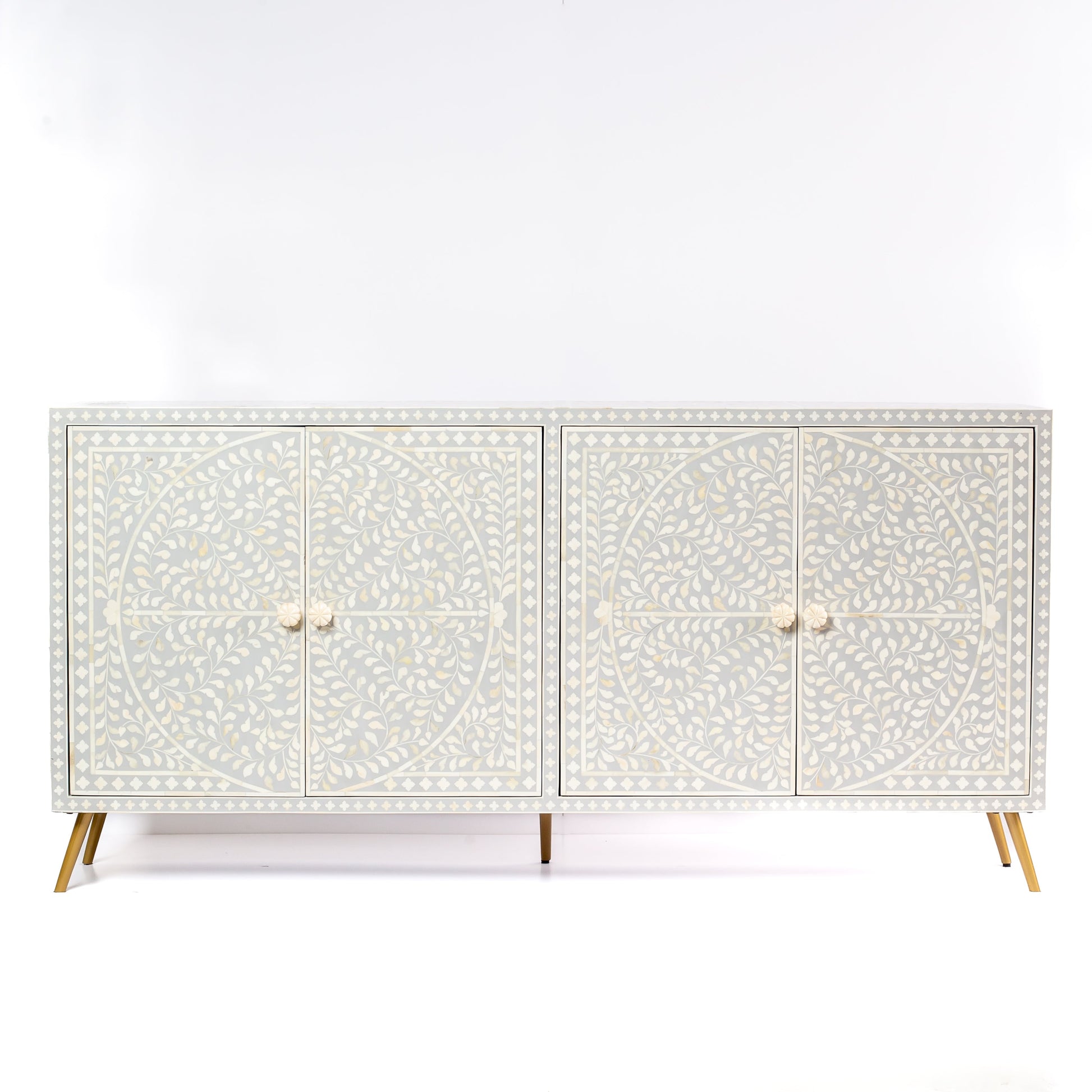 Grey bone inlay cabinet with floral vine pattern, brass legs, and carved bone knobs, handcrafted with spacious storage and artisanal charm.