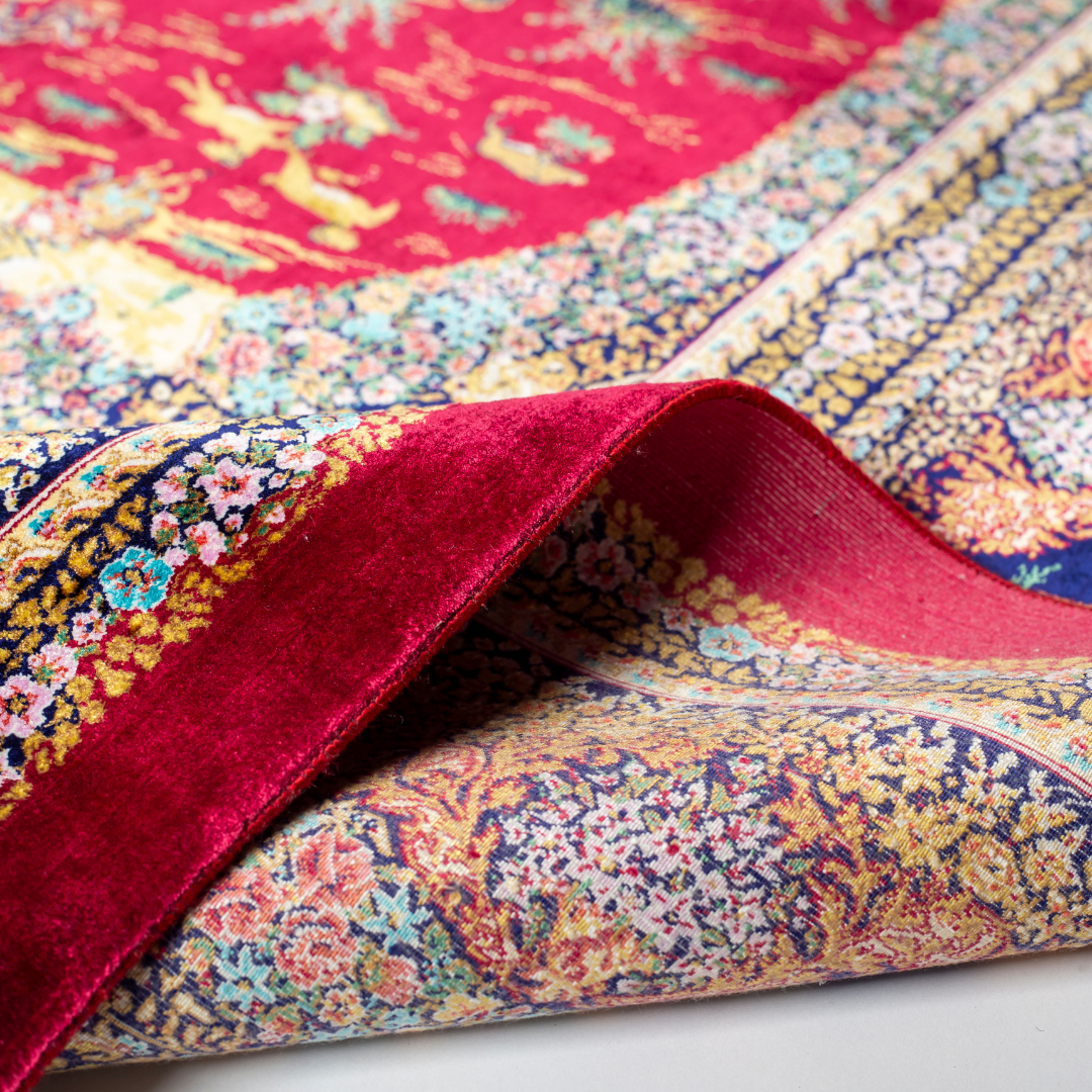 Silk rug in deep garnet red with majestic horsemen, animals, and ornate border work. Handwoven art that brings dynamic motion to interiors.

