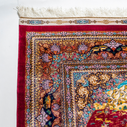 Silk rug in deep garnet red with majestic horsemen, animals, and ornate border work. Handwoven art that brings dynamic motion to interiors.

