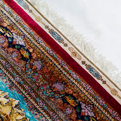 Silk rug in deep garnet red with majestic horsemen, animals, and ornate border work. Handwoven art that brings dynamic motion to interiors.

