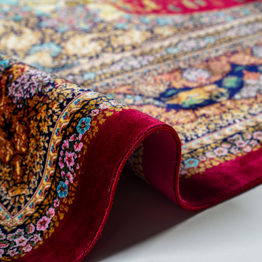 Silk rug in deep garnet red with majestic horsemen, animals, and ornate border work. Handwoven art that brings dynamic motion to interiors.

