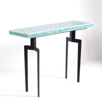 Modern console table with a blue and white patterned top 