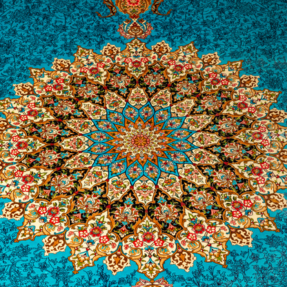 Luxury blue silk rug featuring a detailed central medallion, floral motifs, and ornate bird patterns in gold, coral, and black accents.