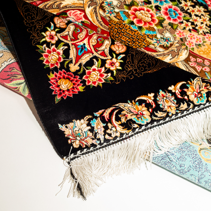 Luxury blue silk rug featuring a detailed central medallion, floral motifs, and ornate bird patterns in gold, coral, and black accents.