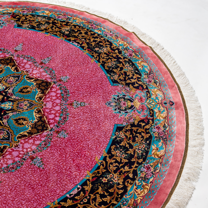 Round silk rug with a vibrant pink base, intricate navy floral borders, and detailed medallion center, 200x200 cm.
