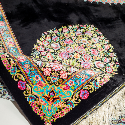 Luxurious silk rug featuring a central medallion in turquoise and pink, floral vases in corners, and ornate borders on a dark base.