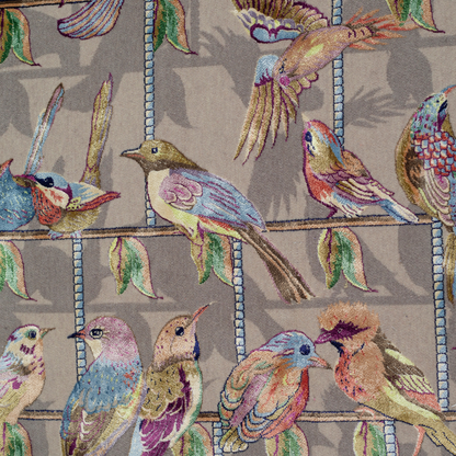 Handwoven silk rug featuring birds on a beige grid, floral corners, and classical columns. A joyful yet elegant statement piece.

